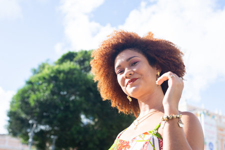 Portrait of beautiful woman with red hair in the late afternoon sun with trees and sky in the background. Concept of peace and harmony with nature.の写真素材