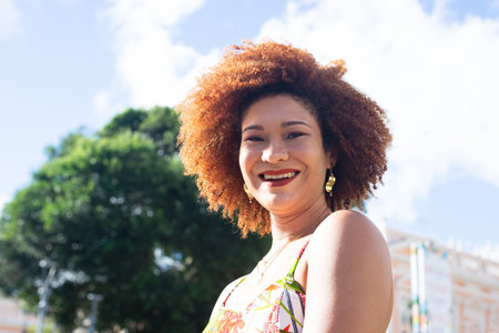 Portrait of beautiful woman with red hair in the late afternoon sun with trees and sky in the background. Concept of peace and harmony with nature.の写真素材