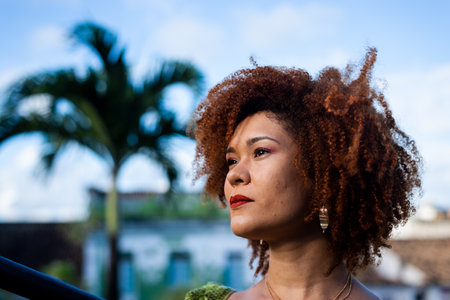 Close-up portrait of the face of a beautiful woman with red hair. In the background the blue sky.