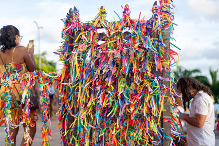 Salvador, Bahia, Brazil - January 07, 2022: Catholics praying next to the iron gate of the Senhor do Bonfim church, covered with ribbons, during an open mass in the city of Salvador, BAhia.のeditorial素材