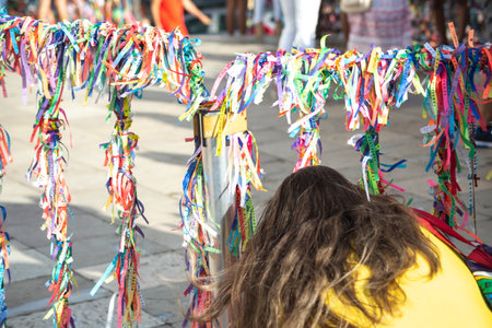Salvador, Bahia, Brazil - January 07, 2022: Catholics are seen tying ribbons on the railing of the Senhor do Bonfim church during an open mass in the city of Salvador, Bahia.のeditorial素材