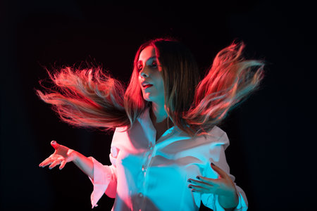 Beautiful, young attractive Caucasian woman wearing white clothing and throwing her hair forward....
