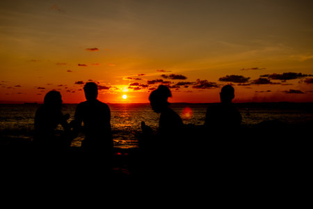 Silhouette of people against romantic and beautiful sunset. Late afternoon with clouds.の写真素材