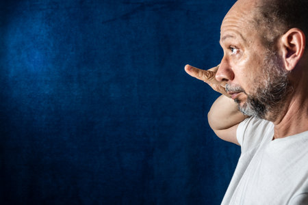 Man, confused, pointing to the side. Sad people. against blue background.の写真素材