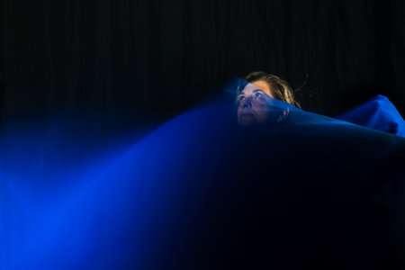 Woman dancer doing abstract performance with blue cloth. Blurred movements.の写真素材