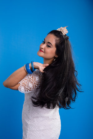 Beautiful young woman in white dress with shell tiara on her head looking to the side. Characterized...