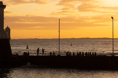 Silhouette of people, at sunset, on the Porto da Barra pier in the city of Salvador, Bahia.の写真素材