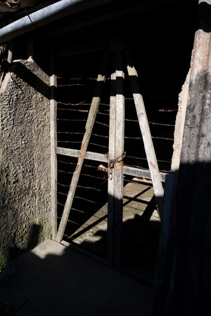Antique wooden door with light and shadow on the facade. Mysterious place.の写真素材