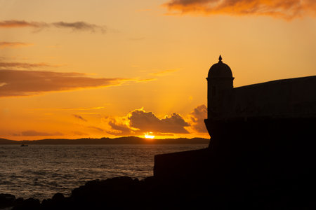 Beautiful dramatic orange sunset. Silhouette of the tip of a nautical fort.の写真素材