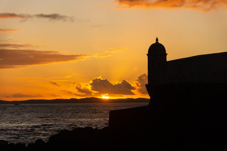 Beautiful dramatic orange sunset. Silhouette of the tip of a nautical fort.の写真素材