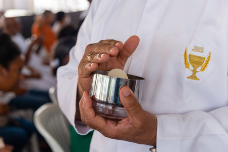 Salvador, Bahia, Brazil - December 29, 2023: A member of the Catholic church is seen distributing hosts during mass at the Senhor do Bonfim church, in the city of Salvador, Bahia.のeditorial素材