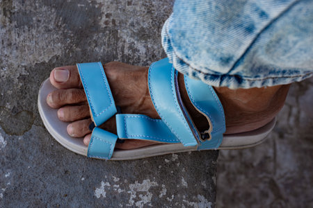 Left foot of an adult wearing a light blue sandal. Fashion shoes.の写真素材
