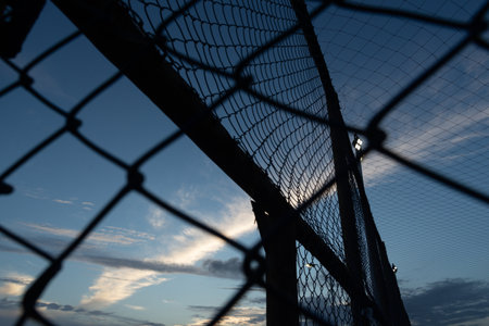 Net and fence of an old abandoned sports court against the sunset. Sport equipment.の写真素材