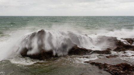 Sea waves crashing hard against a rock in winter. winter storm.の写真素材