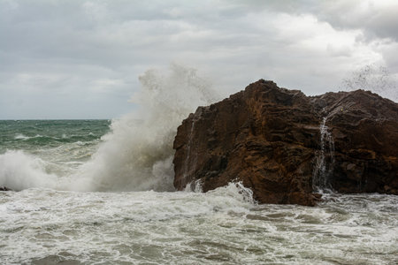 Sea waves crashing hard against a rock in winter. winter storm.の写真素材