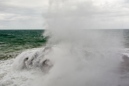 Waves hitting a sea rock with great force. winter storm.