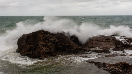 Sea waves crashing hard against a rock in winter. winter storm.の写真素材