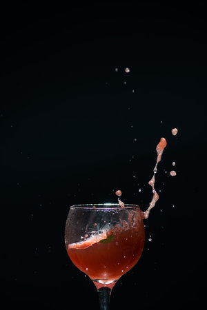 A glass cup with guava juice inside with splashes coming up.の写真素材