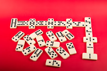 Dominoes with red background, copy space and various angles. White Bones Board Game.の写真素材