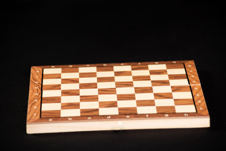 Empty wooden board of a game of checkers or chess on a black background.の写真素材
