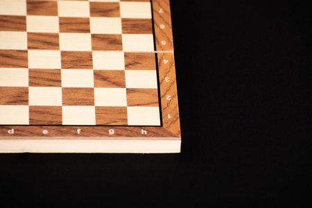 Empty wooden board of a game of checkers or chess on a black background.の写真素材