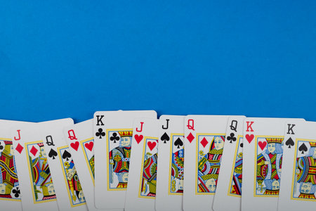 Salvador, Bahia, Brazil - May 10, 2024: Playing cards for poker and gambling, isolated on blue background.のeditorial素材