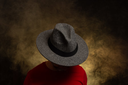 Bearded man wearing hat and posing for photo. portrait in studio. Yellow colored background with artificial smoke.の写真素材