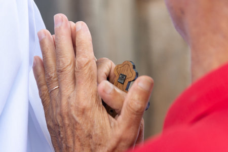 Salvador, Bahia, Brazil - July 27, 2024: Hands of a Catholic faithful holding a rosary during mass in Pelourinho, historic center of the city of Salvador, Bahia.のeditorial素材