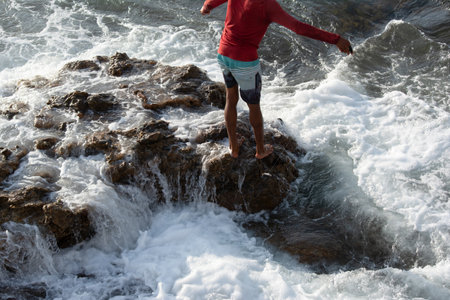 Savior; Bahia; Brazil - April 18; 2019: A fisherman with a nylon line is seen on top of the rocks on Rio Vermelho beach in the city of Salvador, Bahia.のeditorial素材
