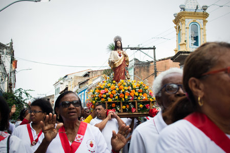 Salvador, Bahia, Brazil - July 27, 2019: Catholic faithful are seen carrying a float during the Sacred Heart of Jesus procession in the historic center of the city of Salvador, Bahia.のeditorial素材