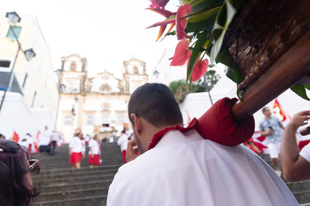 Salvador, Bahia, Brazil - July 27, 2024: Catholic faithful are seen carrying a float and an image of Jesus Christ on the steps of the Church of the Holy Sacrament of Passo, Pelourinho, Bahia.のeditorial素材