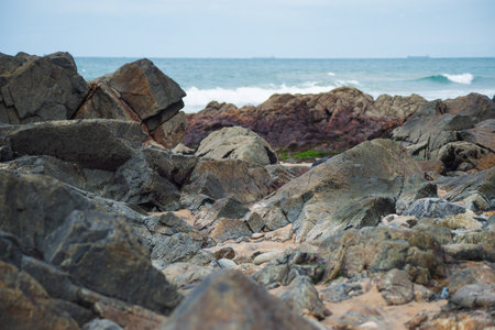 View of dark sea rocks against the ocean and cloudy sky. Preserved nature. Salvador, Brazilの写真素材