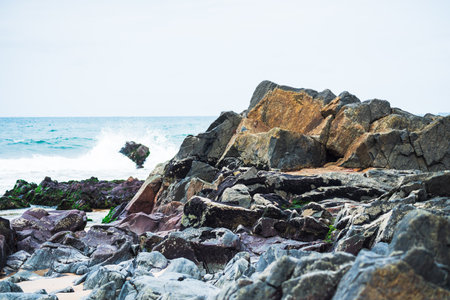 View of dark sea rocks against the ocean and cloudy sky. Preserved nature. Salvador, Brazilの写真素材