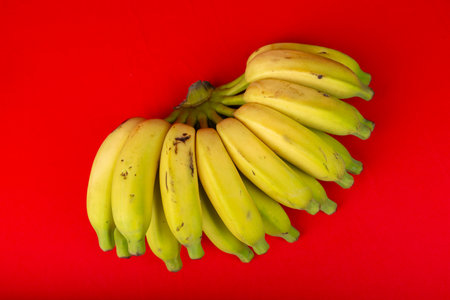 A whole bunch of ripe bananas. Isolated on red background.の写真素材