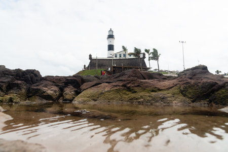 Salvador, Bahia, Brazil - September 01, 2024: Low view of the Barra Lighthouse, during a cloudy day, located in the Barra neighborhood in the city of Salvador, Bahia.のeditorial素材