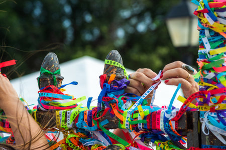 Salvador, Bahia, Brazil - December 27, 2019: Catholics are seen tying colorful ribbons as souvenirs at the gate of the Senhor do Bonfim church in Salvador, Bahia.のeditorial素材