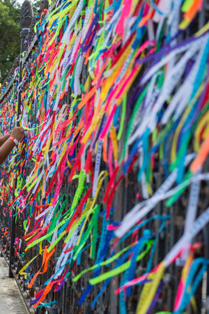 Salvador, Bahia, Brazil - December 27, 2019: Hundreds of colorful souvenir ribbons tied to the gate of the Senhor do Bonfim church in the city of Salvador, Bahia.のeditorial素材