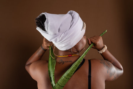Salvador, Bahia, Brazil - October 21, 2024: Woman in traditional CandomblÃ© clothing, showing a tattoo with the word Ogum on her back. Salvador, Bahia.の写真素材