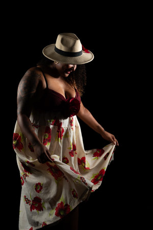 Salvador, Bahia, Brazil - October 21, 2024: Beautiful black woman in traditional clothes and dancing Brazilian Samba in studio. Isolated on black background. Salvador, Bahia.の写真素材
