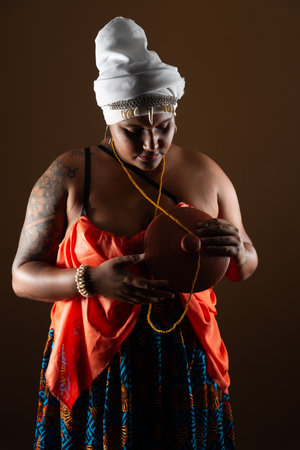 Salvador, Bahia, Brazil - October 21, 2024: Beautiful woman in traditional Candomble clothes holding...