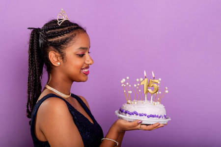 Teenage brunette girl holding a birthday cake and posing for photo. Isolated on lilac background.