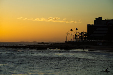 Silhouette of buildings against orange sunset over the sea. Preserved environment. Brazilの写真素材