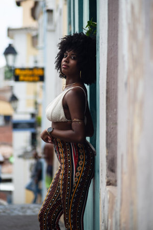Half-length photo of beautiful black woman with her back to an old wall posing for the photo. Smiling and empowered person. Brazilの写真素材