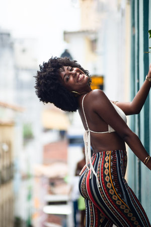 Beautiful, very smiling and happy woman leaning against a wall of an old house. Brazilの写真素材