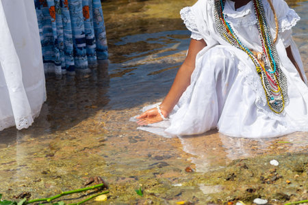 A Candomble practitioner is seen in the water at Rio Vermelho beach paying homage to Iemanja. Salvador, Brazil.の写真素材