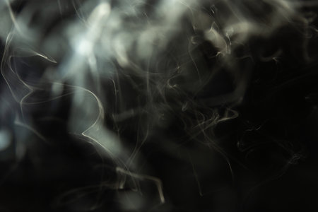 Waves of white smoke, incense smoke isolated on a black background. Studio shot.