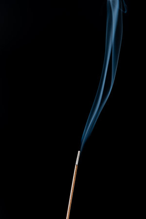 Burning incense with smoke on a black background. Studio shot.の写真素材
