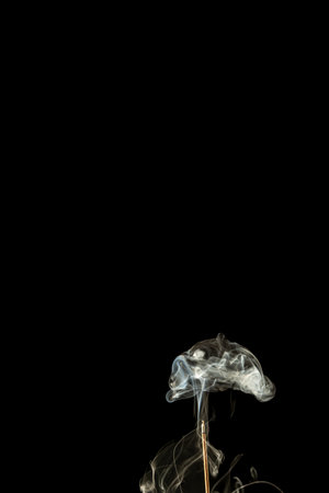 Burning incense with smoke on a black background. Studio shot.の写真素材