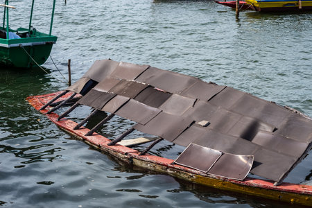 View of the remains of an abandoned wooden boat half sunk in a river. Maritime transportationの写真素材