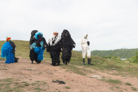 Unidentified people dressed in costume and terrifying mask in a rural area. Carnival day in Brazil.の写真素材